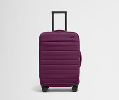 Front product view of The Softside Bigger Carry-On suitcase in Plum Purple with raised handle