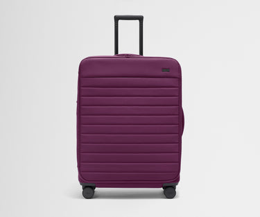 Front product view of The Softside Large suitcase in Plum Purple with raised handle