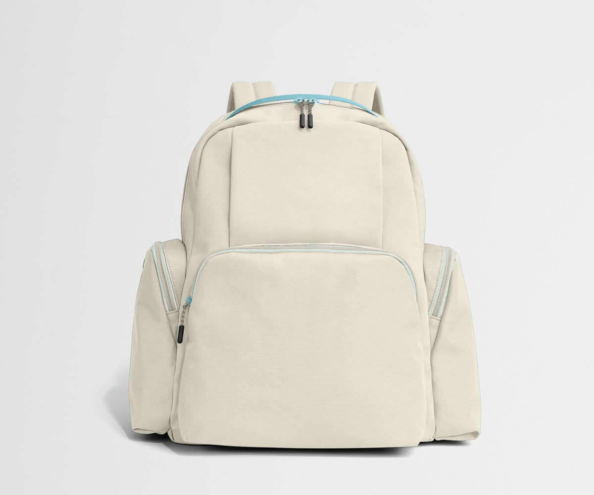 Beige backpack with blue zippers on a light gray background