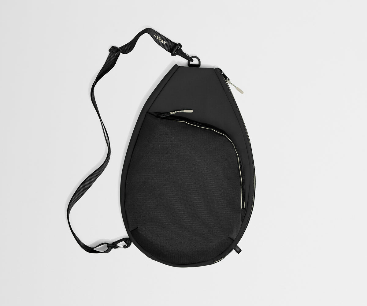 Black sling bag on a light gray background