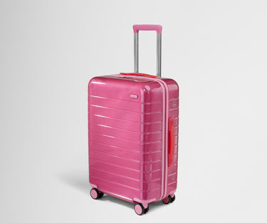 Angled product view of The Bigger Carry-On suitcase in Translucent Pink