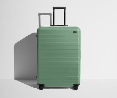 Front product view of The Large suitcase in Sea Green with raised handle