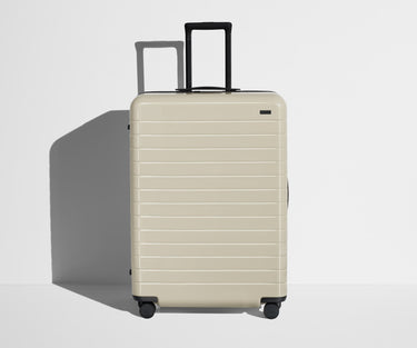 Front product view of The Large suitcase in Salt White (Gloss) with raised handle