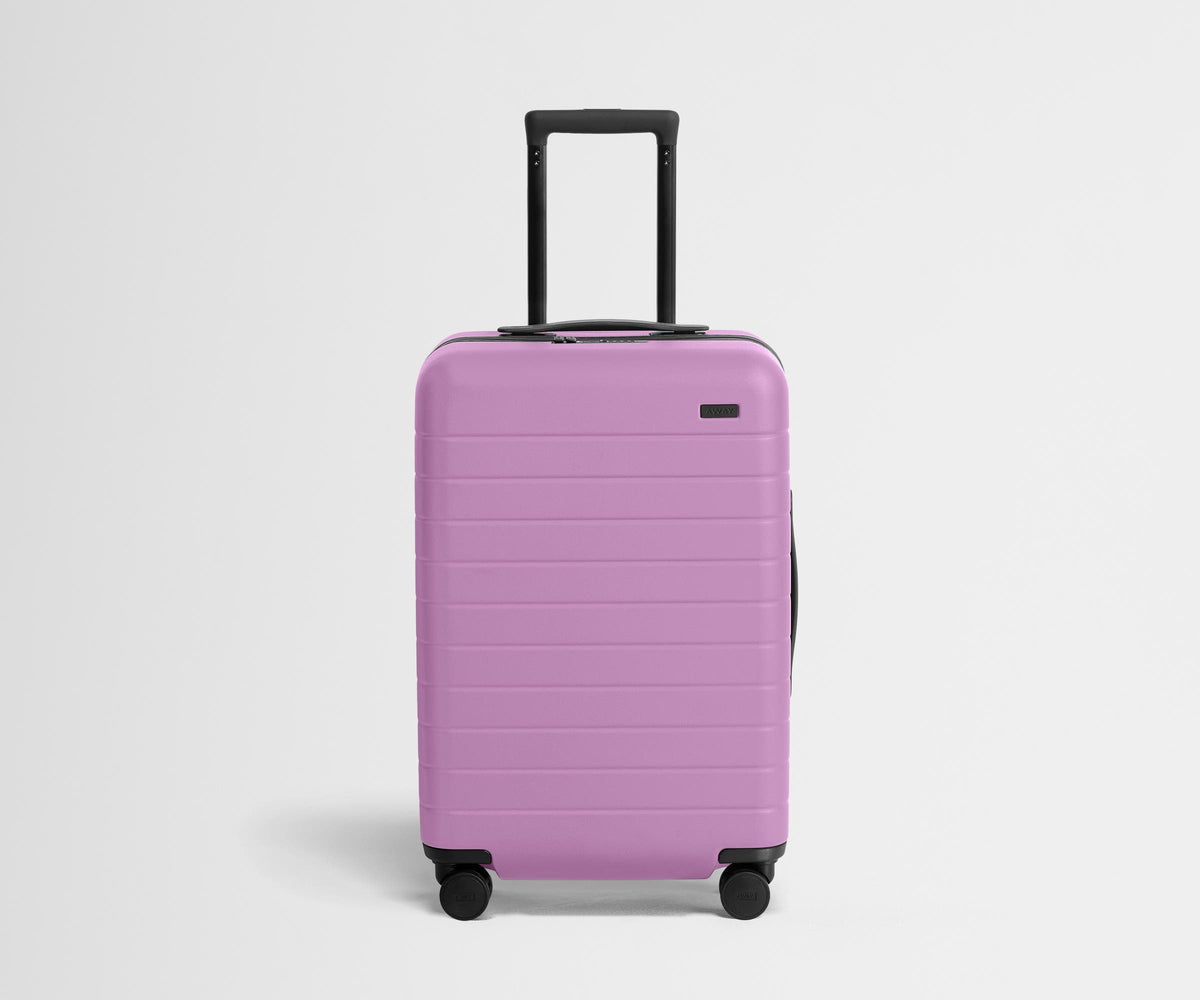 Front product view of The Bigger Carry-On suitcase in Taffy Purple with raised handle