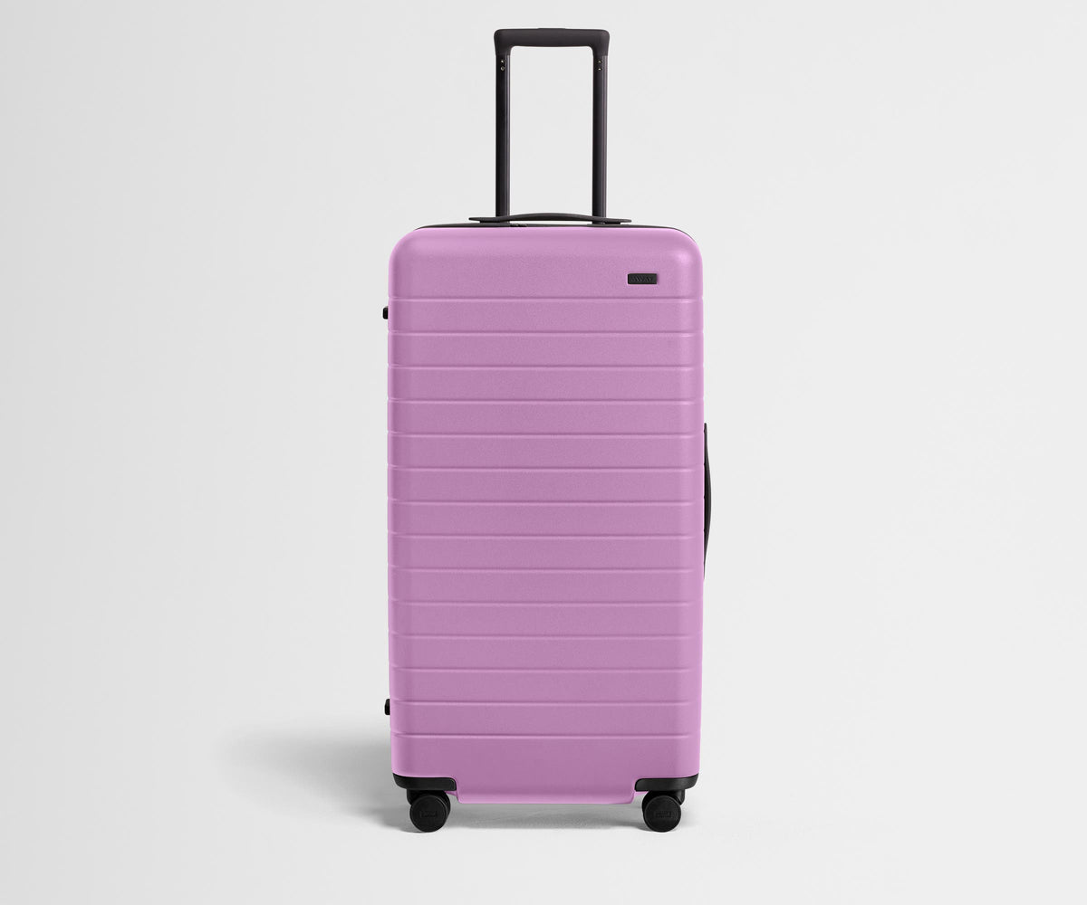 Front product view of The Trunk suitcase in Taffy Purple with raised handle