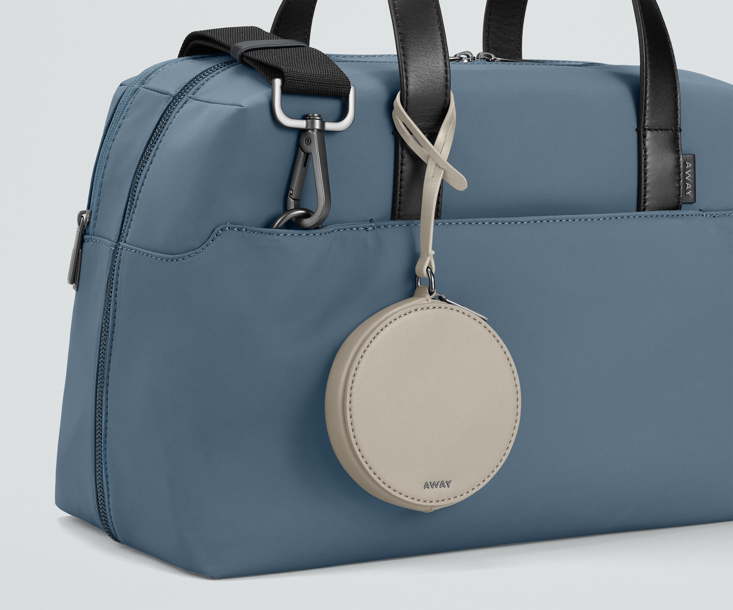 The Circle Zip Pouch looped onto the strap of The Everywhere Bag