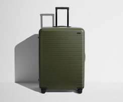 Front product view of The Large suitcase in Olive Green with raised handle