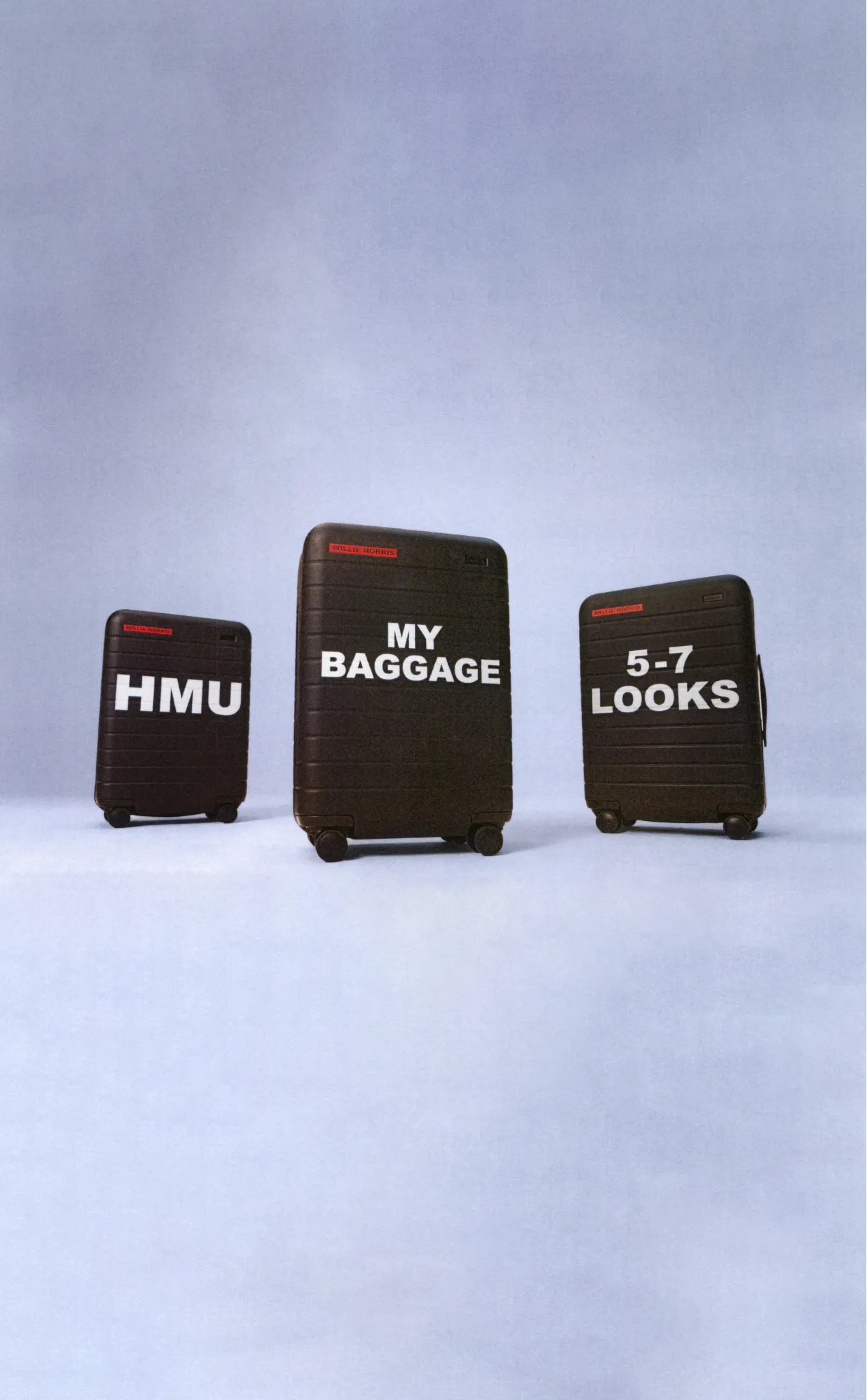 a set of black Away suitcases with text printed on the front of the bags