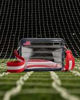 Clear pouch with American flag design on a grass field with netting in the background